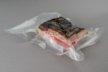 Poster - Guanciale Pork Jowl in vacuum packed sealed for sous vide cooking on Gray background