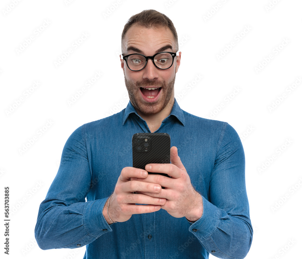 shocked young guy holding telephone and reading emails Stock Photo ...