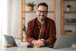 © Dorde - Happy smiling bearded businessman with glasses small business owner, company leader or sales manager, male CEO executive, successful entrepreneur looking at camera sitting in home office.