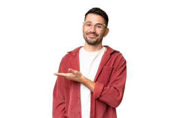 Young handsome caucasian man over isolated chroma key background presenting an idea while looking smiling towards