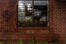 Side Of Crumbling Red Brick Building Left To Rot In Small Rural Georgia Town