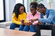 © Krakenimages.com - African american friends using smartphone sitting on sofa at home