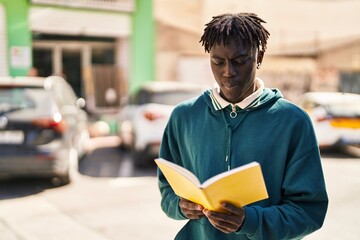 Wall Mural - African american man reading book at street