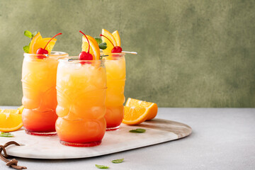 Rum punch in tiki glasses with orange slices and a cherry