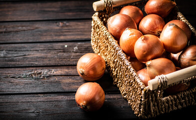 Poster - A full basket of onions on the table. 