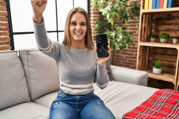 Poster - Young woman holding broken smartphone showing cracked screen annoyed and frustrated shouting with anger, yelling crazy with anger and hand raised