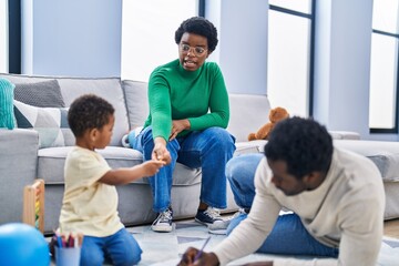 Sticker - African american family drawing on notebook sitting on floor at home