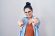 © Krakenimages.com - Young modern girl with blue hair standing over white background pointing to you and the camera with fingers, smiling positive and cheerful