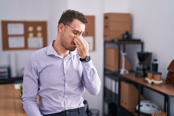 Poster - Young hispanic man at the office tired rubbing nose and eyes feeling fatigue and headache. stress and frustration concept.