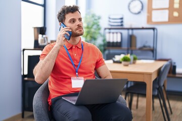 Sticker - Young hispanic man business worker using laptop and talking on the smartphone working at office