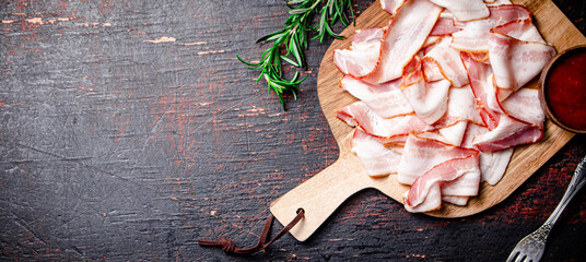 Sticker - Pieces of bacon on a cutting board with tomato sauce.