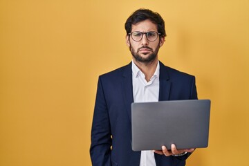 Canvas Print - Handsome latin man working using computer laptop depressed and worry for distress, crying angry and afraid. sad expression.