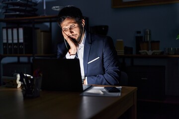 Canvas Print - Handsome latin man working at the office at night thinking looking tired and bored with depression problems with crossed arms.