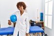 © Krakenimages.com - Young african american woman wearing physio uniform holding fit ball at clinic