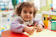 © Krakenimages.com - Adorable hispanic girl preschool student sitting on table drawing on paper at kindergarten