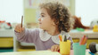 © Krakenimages.com - Adorable hispanic girl preschool student sitting on table drawing on paper at kindergarten