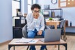 © Krakenimages.com - Hispanic man doing video call waving to laptop covering mouth with hand, shocked and afraid for mistake. surprised expression