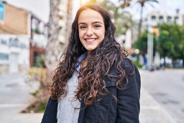 Young hispanic woman smiling confident standing at street