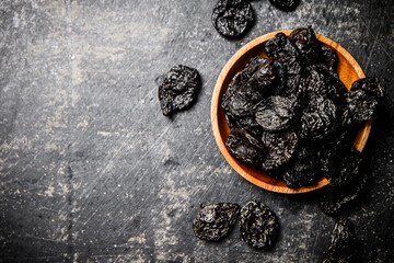 Poster - Prunes in a wooden plate on the table. 