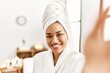 © Krakenimages.com - Young latin woman wearing bathrobe make selfie by the camera at beauty center