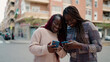© Krakenimages.com - Two african american friends smiling confident using smartphone at street