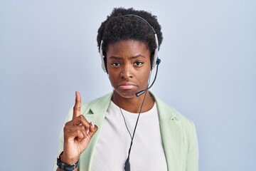 Canvas Print - African american woman wearing call center agent headset pointing up looking sad and upset, indicating direction with fingers, unhappy and depressed.