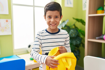 Sticker - Adorable hispanic boy student smiling confident opening backpack at kindergarten