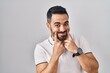 © Krakenimages.com - Young hispanic man with beard wearing casual clothes over white background smiling with open mouth, fingers pointing and forcing cheerful smile