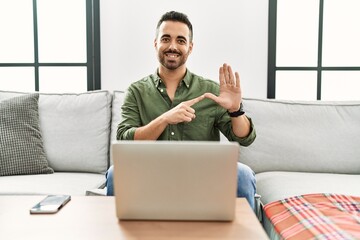 Canvas Print - Young hispanic man having video call speaking with deaf language at home