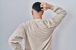 © Krakenimages.com - Young handsome man standing over isolated background backwards thinking about doubt with hand on head