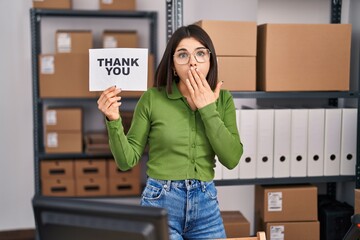Wall Mural - Young hispanic doctor woman working at small business ecommerce holding thank you banner covering mouth with hand, shocked and afraid for mistake. surprised expression