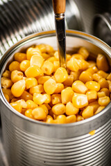 Poster - An open can of canned corn with a spoon. 