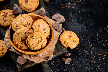 Wall Mural - Cookies with pieces of milk chocolate on a cutting board. 