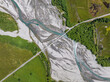 Bird's eye aerial drone view of Glenorchy-Paradise Road crossing over Rees River near Glenorchy, Lake Wakatipu and Queenstown, South Island, New Zealand. The area is a popular tourist destination.