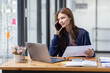 © David - Cheerful business Asian woman freelancer making telephone call share good news about project working in office workplace, business finance concept.
