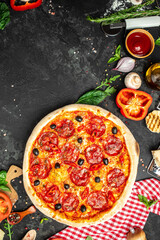 Wall Mural - spicy pepperoni pizza, Tomato sauce, pepper, Italian pizza on dark table background. Restaurant menu, dieting, cookbook recipe top view