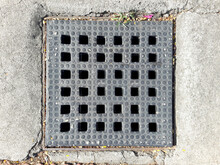 Blacktop Drains Are Covered With Square Plastic Grids. Road Covered With Substrate. The Area Around The Drain Is Covered With A Mulch. Plastic Gutters, And Stone Pavement Sidewalks