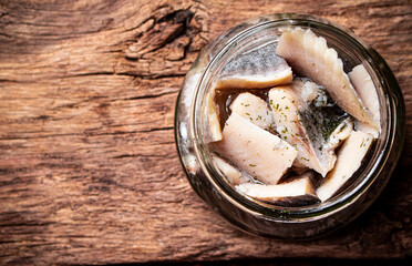 Poster - A glass jar with pieces of salted herring. 