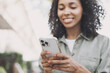 © kite_rin - Young beautiful woman using smartphone in a city. Smiling student girl texting on mobile phone outdoor. Modern lifestyle, connection, casual business concept