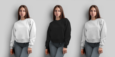 Wall Mural - Mockup of a white, black, heather crop sweatshirt on a girl, women's shirt for design, isolated on a wall background, front view.