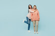 Full body smiling happy fun cheerful cool elder parent mom with young adult daughter two women together wear casual clothes look camera hugging isolated on plain blue background. Family day concept.