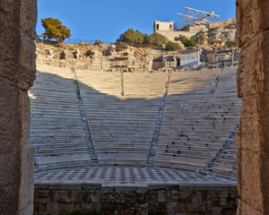 Wall Mural - The ancient Athens temple of Nike above the stands of the conservatory of Herod Atticus, as seen through an arch. Cultural travel in Athens, Greece.