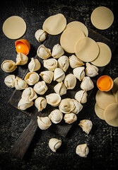 Sticker - Raw dumplings on cutting board with egg.