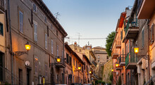 Italy, Lazio, Capodimonte, Rows Of Houses And Glowing Street Lights At Dusk