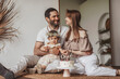 © Westend61 - Happy parents with cute baby girl sitting in front of cake at home