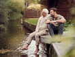 © Westend61 - Adult son sitting with father in garden