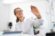 © Westend61 - Smiling mature businesswoman examining tree model in office
