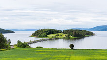 Little Green Island Covered With Trees And Grass Connected By A Dam In Norway