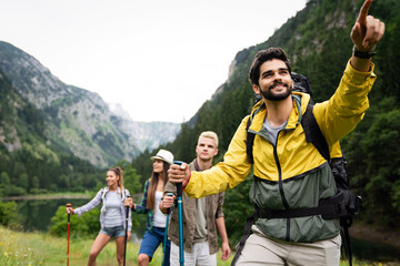 Wall Mural - group of friends with backpacks doing trekking excursion on mountain