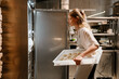 © Drobot Dean - Young blonde woman putting food in refrigerator working in kitchen